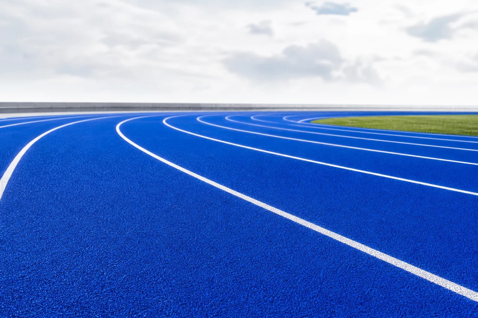 Empty electric blue running track with white lane lines